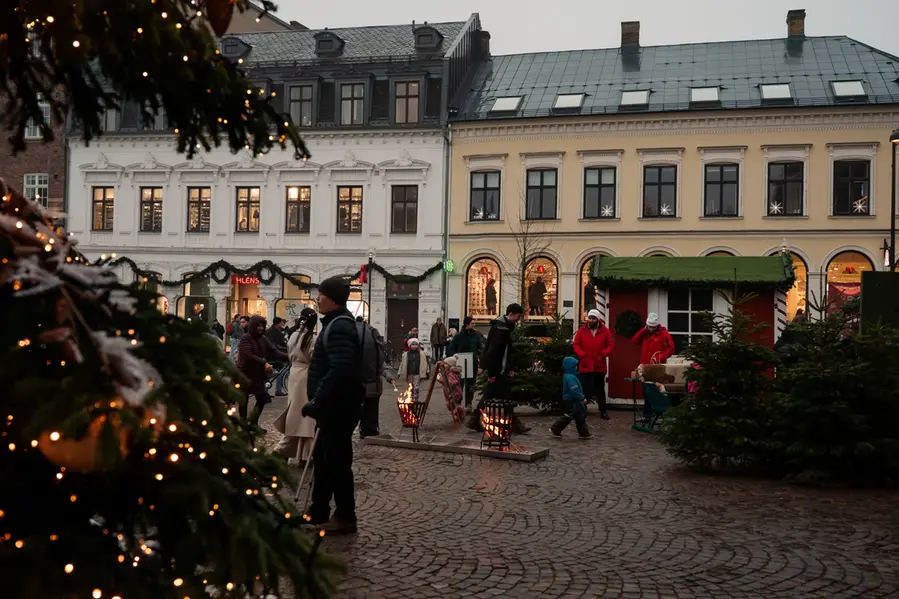 Julstämning på Stortorget, med dekorerad julgran med ljus och aktiviteter för barn.